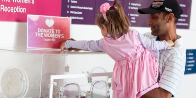 Adding to a donation box at the Women's