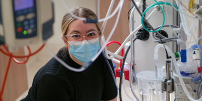 Researcher surrounded by clinical equipment in the NICU